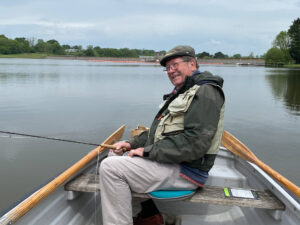 A happy angler Bruce fishing on the reservoir from a boat