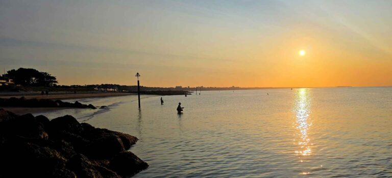 Flyfishers in sea with sunrise